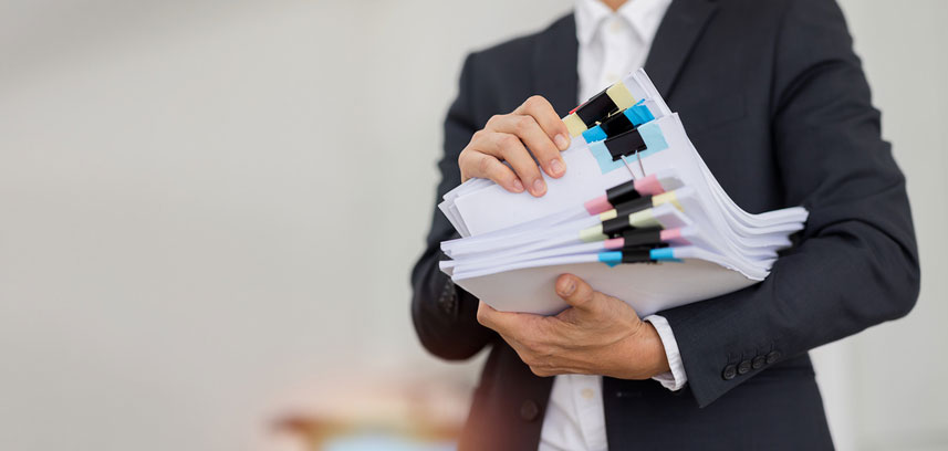 paralegal carrying stacks of documents